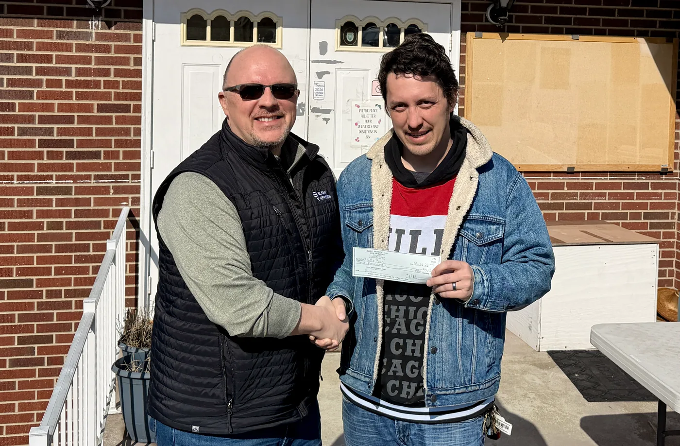 Eric presenting a donation check to a local community organization
